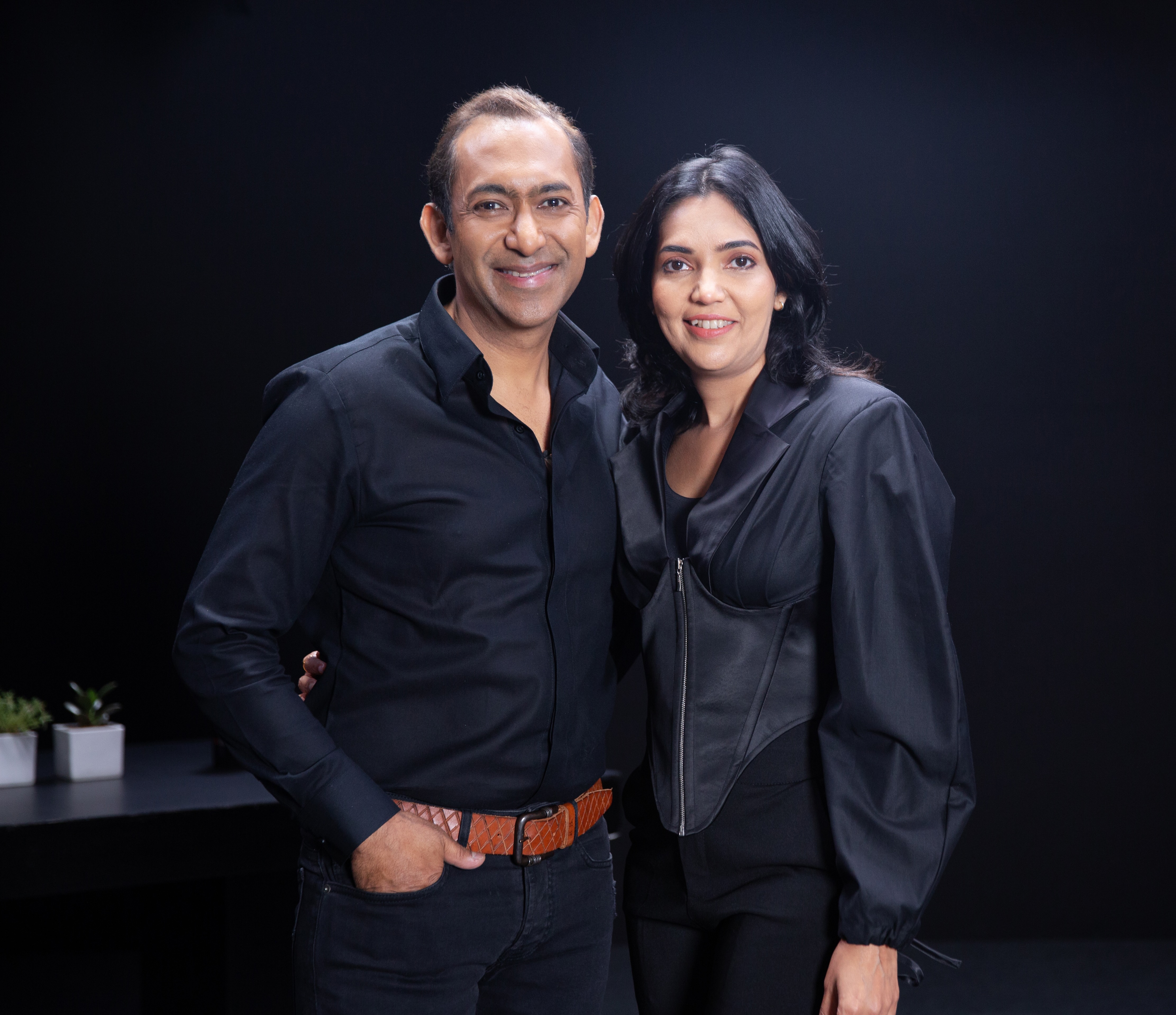 Ritesh and Dimple Bawri, founders of nira kitchen, photographed against a charcoal studio backdrop